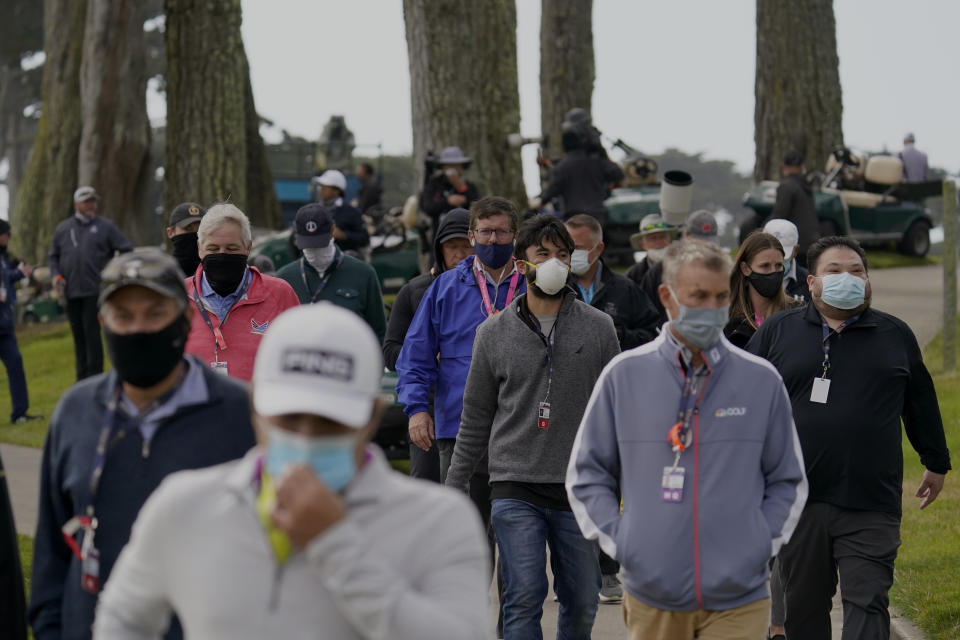 Members of the gallery wearing face mass follow the Tiger Woods group on the 13th hole during the first round of the PGA Championship golf tournament at TPC Harding Park Thursday, Aug. 6, 2020, in San Francisco. (AP Photo/Jeff Chiu)