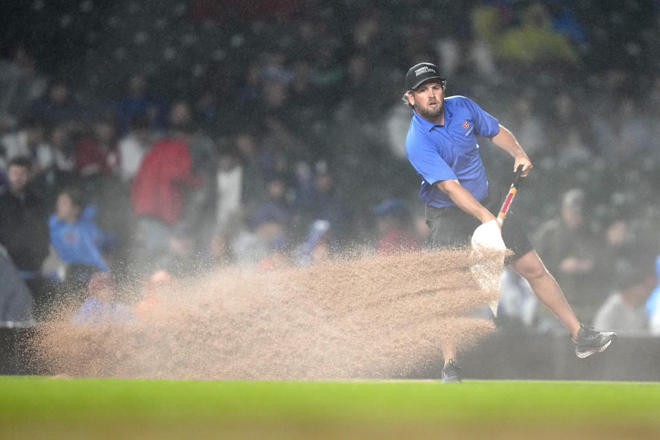 A member of the grounds crew works on the infield during the third inning of a rain-plagued baseball game between the Chicago Cubs and the Cincinnati Reds on Saturday, June 1, 2024, in Chicago. (AP Photo/Charles Rex Arbogast)