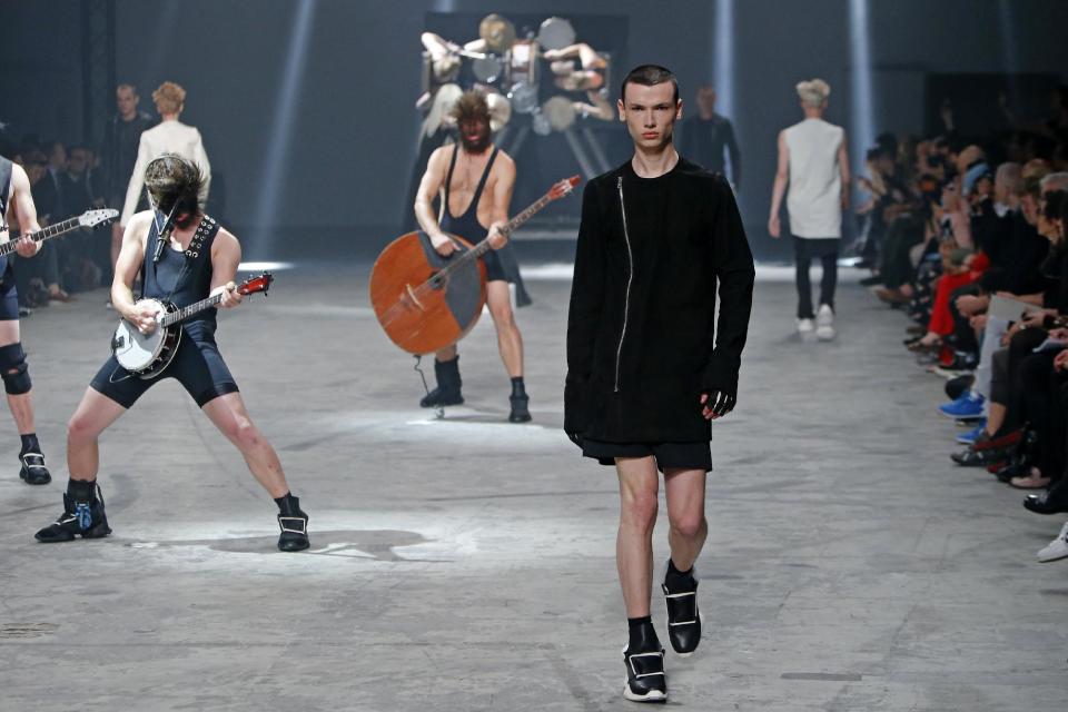 A model wears a creation by fashion designer Rick Owens as part of his men's fashion Spring-Summer 2014 collection, presented Thursday, June 27, 2013 in Paris, as Estonian metal/punk band Winny Puhh performs live, rear left. (AP Photo/Francois Mori)
