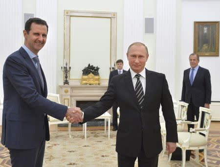 Russian President Vladimir Putin (R) shakes hands with Syrian President Bashar al-Assad during a meeting at the Kremlin in Moscow, Russia, in this October 20, 2015 file photo. REUTERS/Alexei Druzhinin/RIA Novosti/Kremlin/ Files