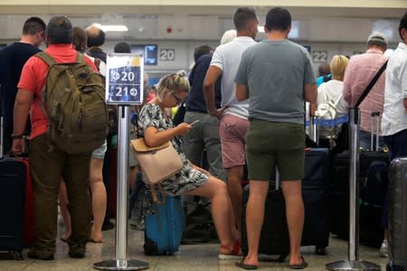 Thomas Cook passengers queue up in a check-in service at Malta International Airport