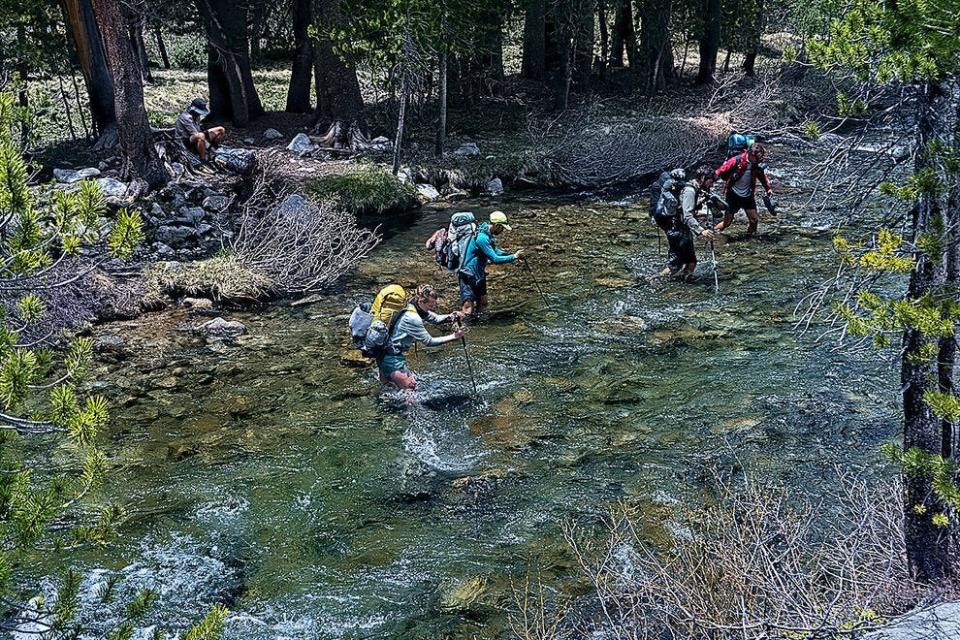 Hikers crossing Evolution Creek in Kings Canyon National Park