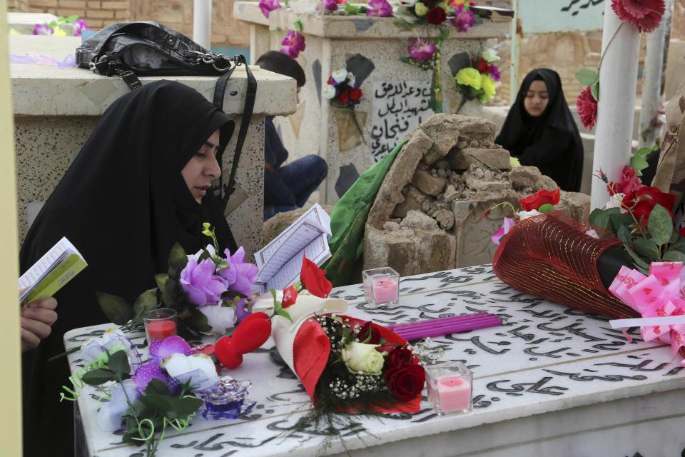 In this Wednesday, Feb. 15, 2017 photo, family members of Iraqi Army officer, Hamza Finjan, pray over his grave in Wadi al-Salam, or "Valley of Peace" cemetery which contains the graves of security forces and militiamen killed from fighting with Islamic State group militants, in Najaf, 100 miles (160 kilometers) south of Baghdad, Iraq. Hundreds of Iraqi soldiers are estimated to have died in the fight for Mosul so far, but the Iraqi government does not release official casualty reports, a move that many Iraqis view as disrespectful of their sacrifice. (AP Photo/ Khalid Mohammed)