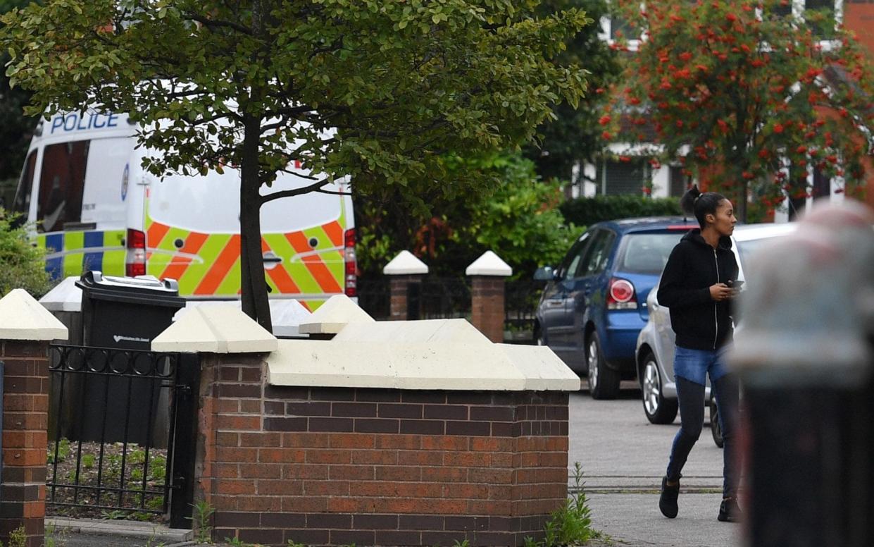 Police stand outside an address in Blossomville Way - PA