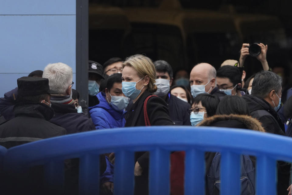 FILE - In this Jan. 31, 2021, file photo, the World Health Organization team is briefed outside of the Huanan Seafood Market on the third day of their field visit in Wuhan, China. Chinese officials briefed diplomats Friday, Masrch 26, 2021, on the ongoing research into the origin of COVID-19, ahead of the expected release of a long-awaited report from the World Health Organization. (AP Photo/Ng Han Guan, File)