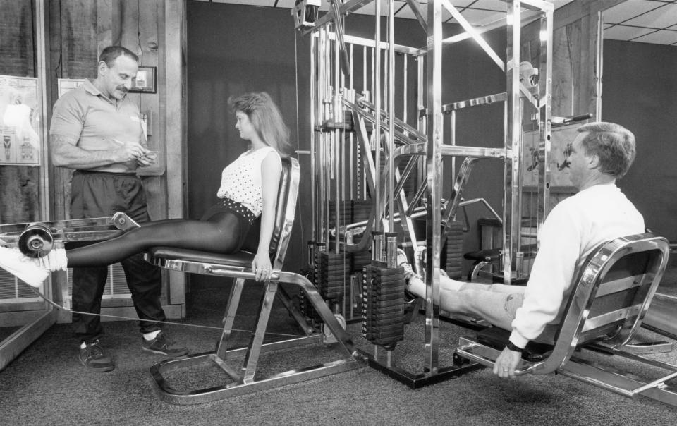 Maryville's Olympia Athletic Club owner/trainer Lon Herzbrun, left, talks to Dawb Webb, of Wildwood, about her training program. At right is Tom Fesmire, of Maryville. "Americans are so overweight right now," said Herzbrun. "This is killing them. They're lazy."