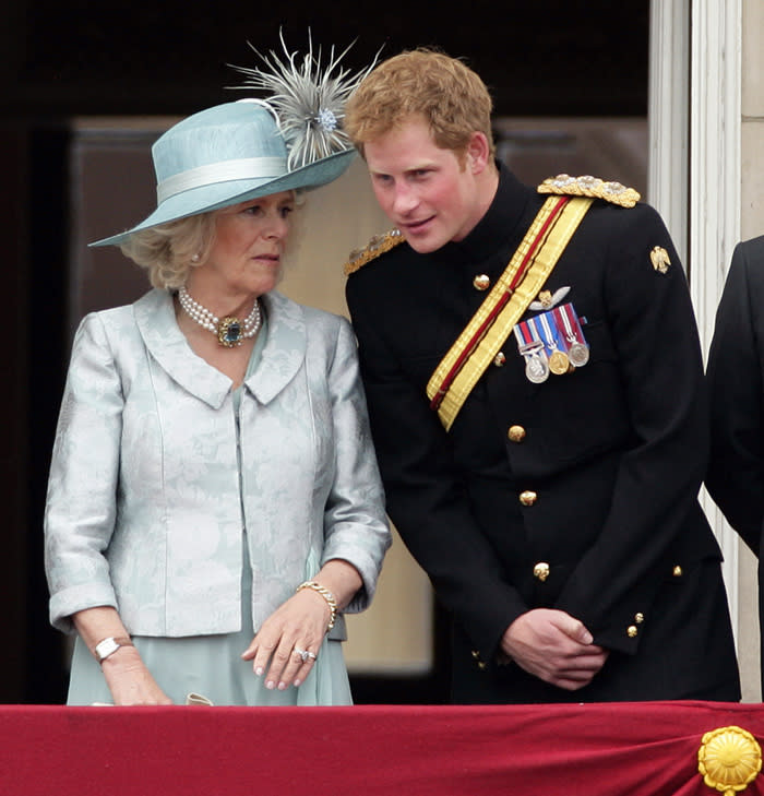 El príncipe Harry hablando con la reina Camilla en un balcón de Buckingham