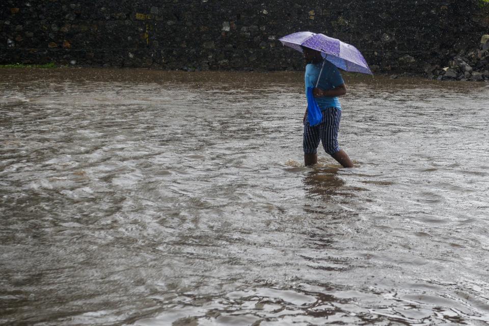 A boy wades through a flooded during a heavy monsoon rain in Mumbai on August 4, 2020. (Photo by INDRANIL MUKHERJEE/AFP via Getty Images)