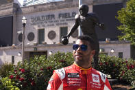 NASCAR driver Bubba Wallace poses for photos outside Soldier Field, near a statue of Walter Payton, on Tuesday, July 19, 2022, in Chicago during a promotional visit to announce a Cup Series street race in the city, to be held July 2, 2023. (AP Photo/Charles Rex Arbogast)
