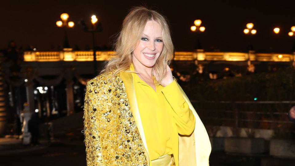 Kylie Minogue in gold suit with yellow shirt