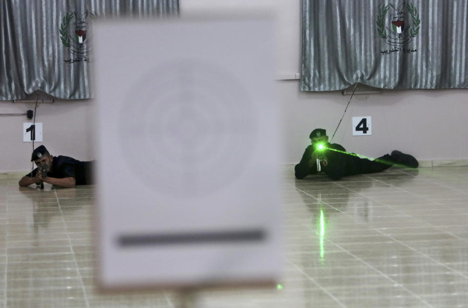 Palestinian security officers Muhmmad Debo, 22, left, and Ahed Abu Shabban, 23, right, shoot electronically-modified AK-47 rifles at the headquarters of the security training department of the Hamas interior ministry in Gaza City, in the northern Gaza Strip on Thursday, April 10, 2014. Hamas says the quiet, indoor facility is less likely to attract the attention of the Israeli military than the open-air firing ranges that are frequently targeted in airstrikes. (AP Photo/Adel Hana)