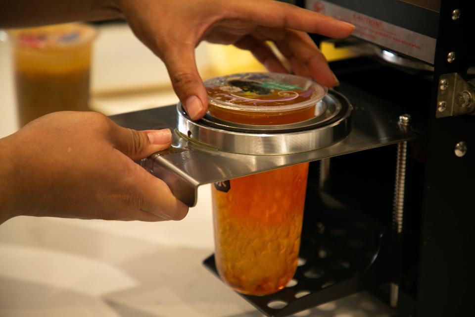 An employee grabs a drink she prepared for a customer at Cha³ Tea in Portland on Saturday, May 27, 2023.