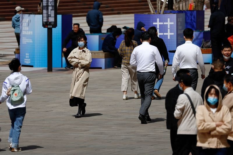 FILE PHOTO: FILE PHOTO: People walk on a street at a shopping area in Beijing