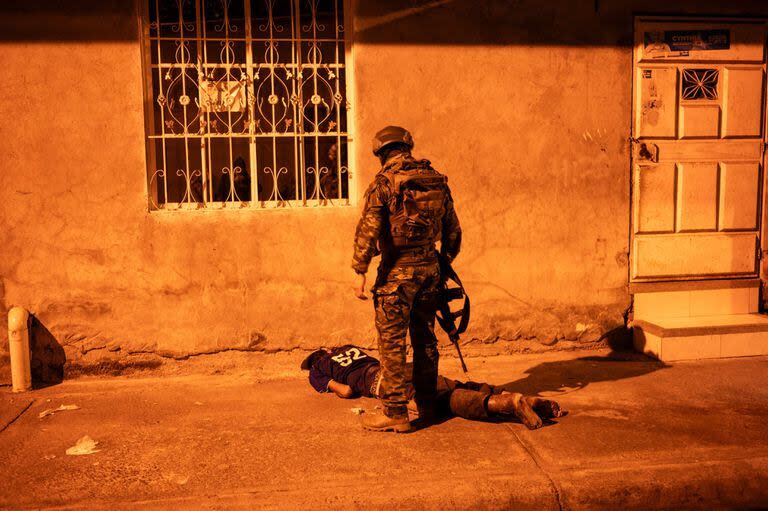 Un soldado retiene a un hombre en una operación de seguridad y búsqueda de sospechosos durante el toque de queda, en un barrio de Guayaquil, Ecuador, en las primeras horas del 12 de enero de 2024. 