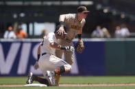 San Diego Padres second baseman Jake Cronenworth, top, looks toward first base after forcing San Francisco Giants' Mike Tauchman, bottom, out at second base on a double play hit into by Wilmer Flores during the first inning of a baseball game in San Francisco, Saturday, May 8, 2021. (AP Photo/Jeff Chiu)