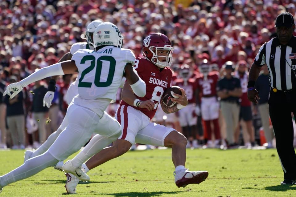 OU quarterback Dillon Gabriel (8) runs the ball as Baylor safety Devin Lemear (20) chases during the first half Saturday in Norman.