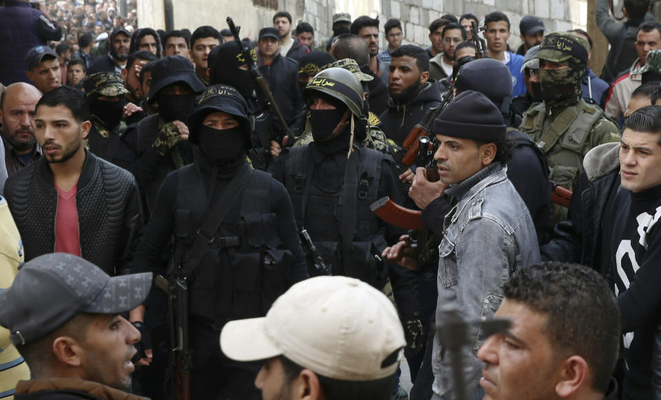 Masked Islamic Jihad militants attend the funeral of Jihad Hararah, during his funeral in front of his family house in Shijaiyah neighborhood in Gaza City, Saturday, March 23, 2019. Gaza's Health Ministry said Hararah, died shortly after he shot at his face yesterday by Israeli troops during a protest at the Gaza Strip's border with Israel. (AP Photo/Adel Hana)