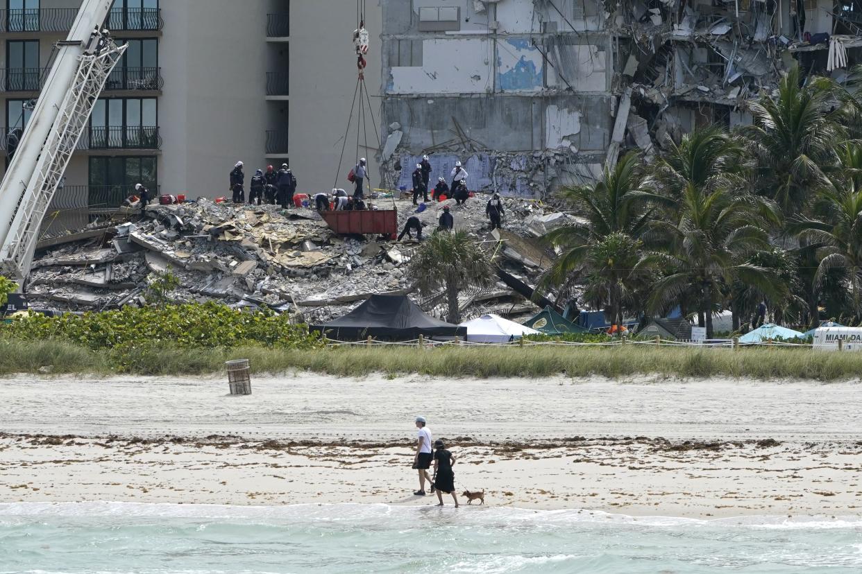 Rescue workers search in the rubble at the Champlain Towers South condominium, Saturday, June 26, 2021, in the Surfside area of Miami. The building partially collapsed on Thursday.