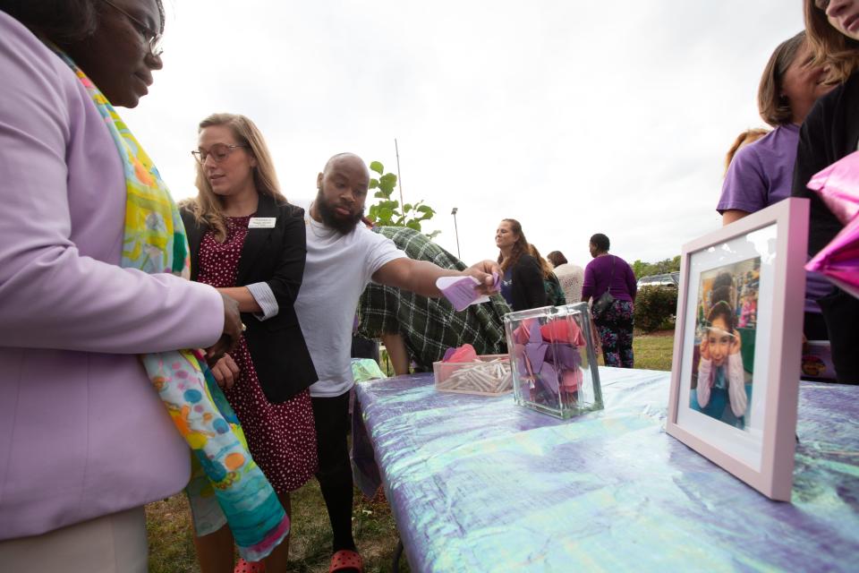 Community members joined Topeka Public Schools USD 501 and Shaner Elementary School staff to honor the late Zoey Felix by writing messages on hearts and dedicating a marigold tree in front of her former school during a ceremony on Oct. 12.