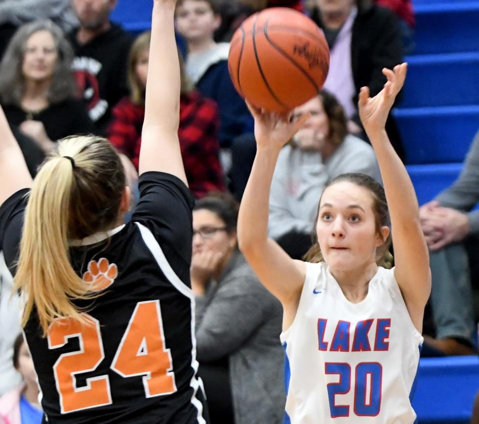 Lake's Hayden Croyle puts the ball up over Green's Jenna Slates in the first quarter of Green at Lake girls basketball. Wednesday, December 20, 2023.
