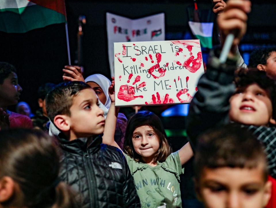 A young girl holds a sign up saying “Israel is killing children like me!!” surrounded by other children at the community rally in support of freeing Palestine at Ford Community & Performing Arts Center in Dearborn on Tuesday, Oct. 10, 2023. Hamas militants attacked Israel on Saturday, killing more than 900 people, including at least 14 Americans. Israel has responded with a siege and heavy bombing of the Gaza Strip resulting in over 1500 deaths total.