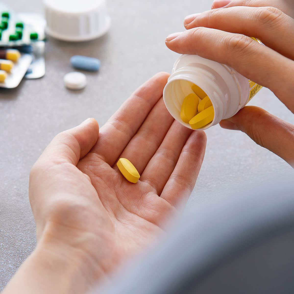 woman dispensing yellow pills