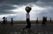 Rohingya refugees walk on the shore after crossing the Bangladesh-Myanmar border by boat through the Bay of Bengal in Shah Porir Dwip, Bangladesh September 11, 2017. REUTERS/Danish Siddiqui