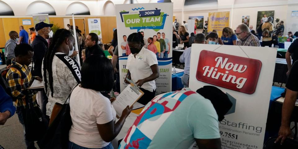 Job applicants fill out forms with CSC Global, left, and Skilled Staffing, right, at the 305 Second Chance Job & Resource Expo, Friday, June 10, 2022, in Miami