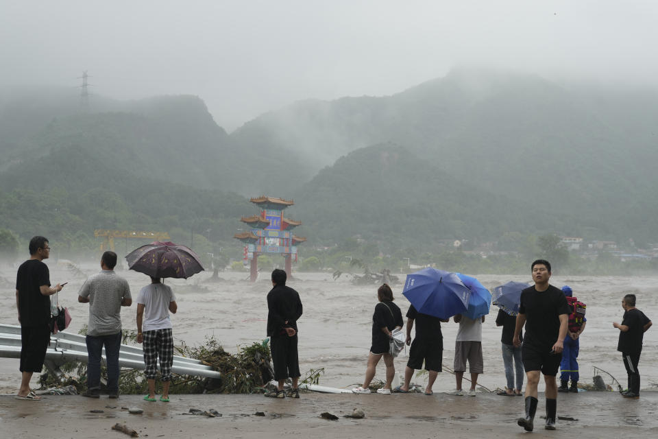 Residents look over an area inundated by flood waters in Miaofengshan on the outskirts of Beijing, Tuesday, Aug. 1, 2023. Chinese state media report some have died and others are missing amid flooding in the mountains surrounding the capital Beijing. (AP Photo/Ng Han Guan)