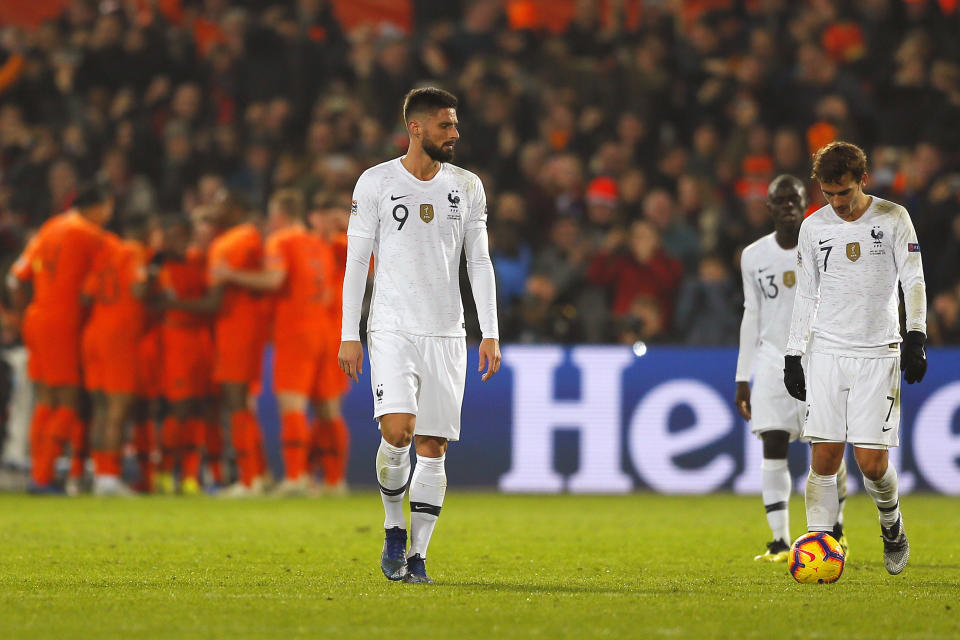 France's Olivier Giroud, left, and France's Antoine Griezmann, right, appear dejected as Netherlands players celebrate scoring their side's first goal during the international friendly soccer match between The Netherlands and France at De Kuip stadium in Rotterdam, Netherlands, Friday, Nov. 16, 2018. (AP Photo/Peter Dejong)