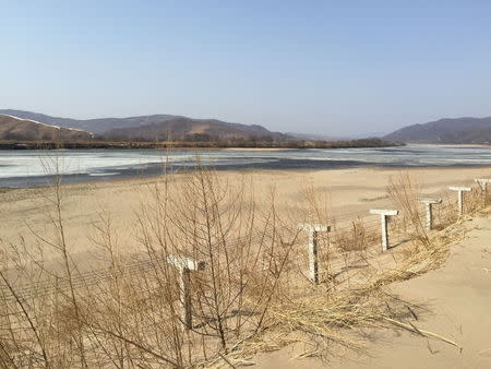 A barbed-wire fence separating North Korea from China is seen in this photo taken from the Chinese border city of Hunchun, China, March 18, 2015. REUTERS/Staff