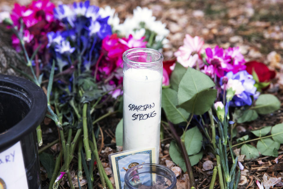 A vigil candle reading "Spartan Strong," and flowers sit outside Berkey Hall following a mass shooting on campus the night before, at Michigan State University, in East Lansing, Mich., Tuesday, Feb. 14, 2023. (Brice Tucker/mlive.com/The Flint Journal via AP)