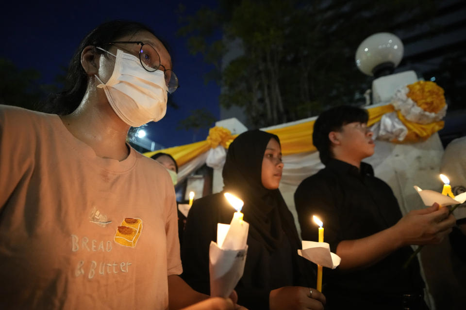 Thai activists hold candles during a vigil for Netiporn Sanesangkhom, a member of the activist group Thaluwang, known for their bold and aggressive campaigns demanding reform of the monarchy and abolition of the law that makes it illegal to defame members of the royal family, outside of Criminal court in Bangkok, Thailand, Tuesday, May 14, 2024. Netiporn who went on a hunger strike after being jailed for her involvement in protests calling for reform of the country's monarchy system died Tuesday in a prison hospital, officials said. (AP Photo/Sakchai Lalit)