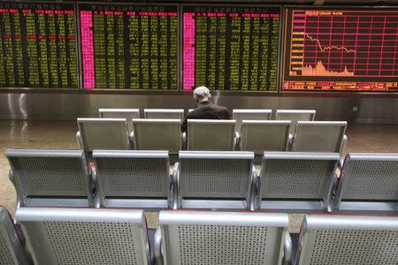 An investor sits in front of an electronic board showing stock information at a brokerage house in Beijing, China, January 4, 2016. REUTERS/Li Sanxian