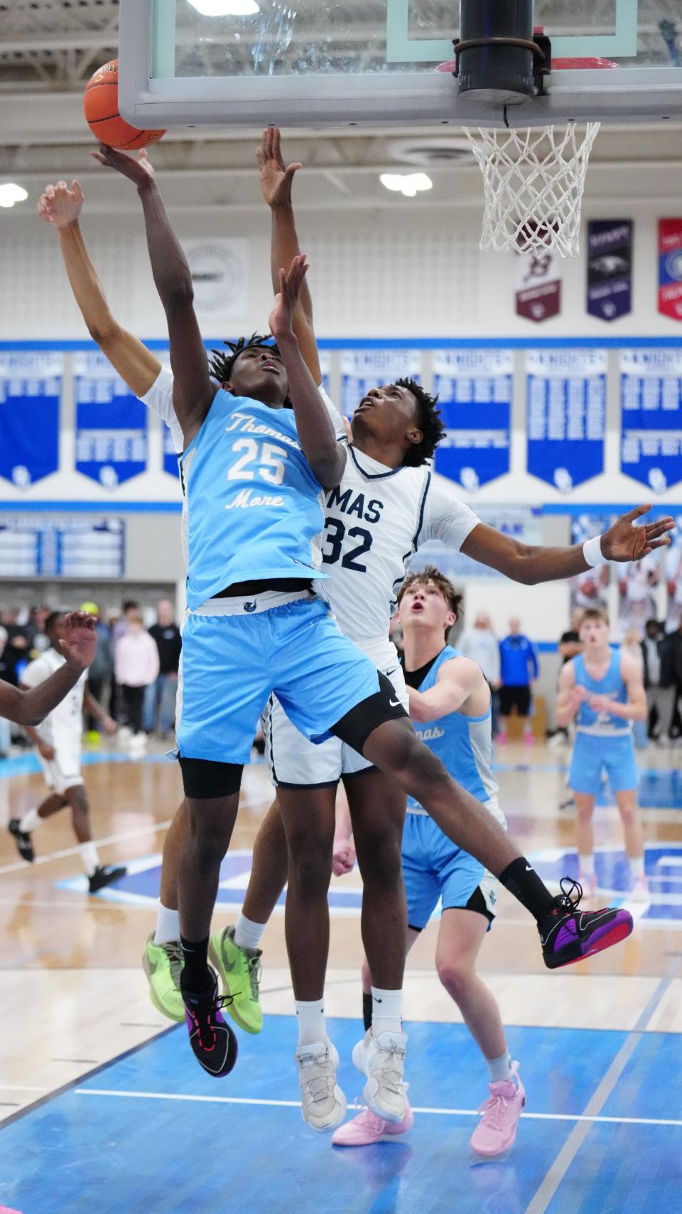 St. Thomas More's Sekou Konneh (25) is fouled by Milwaukee Academy of Science's Elijah Thornton (32) during the WIAA D3 boys basketball sectional semifinal at Oak Creek High School on Thursday, March 7, 2024.