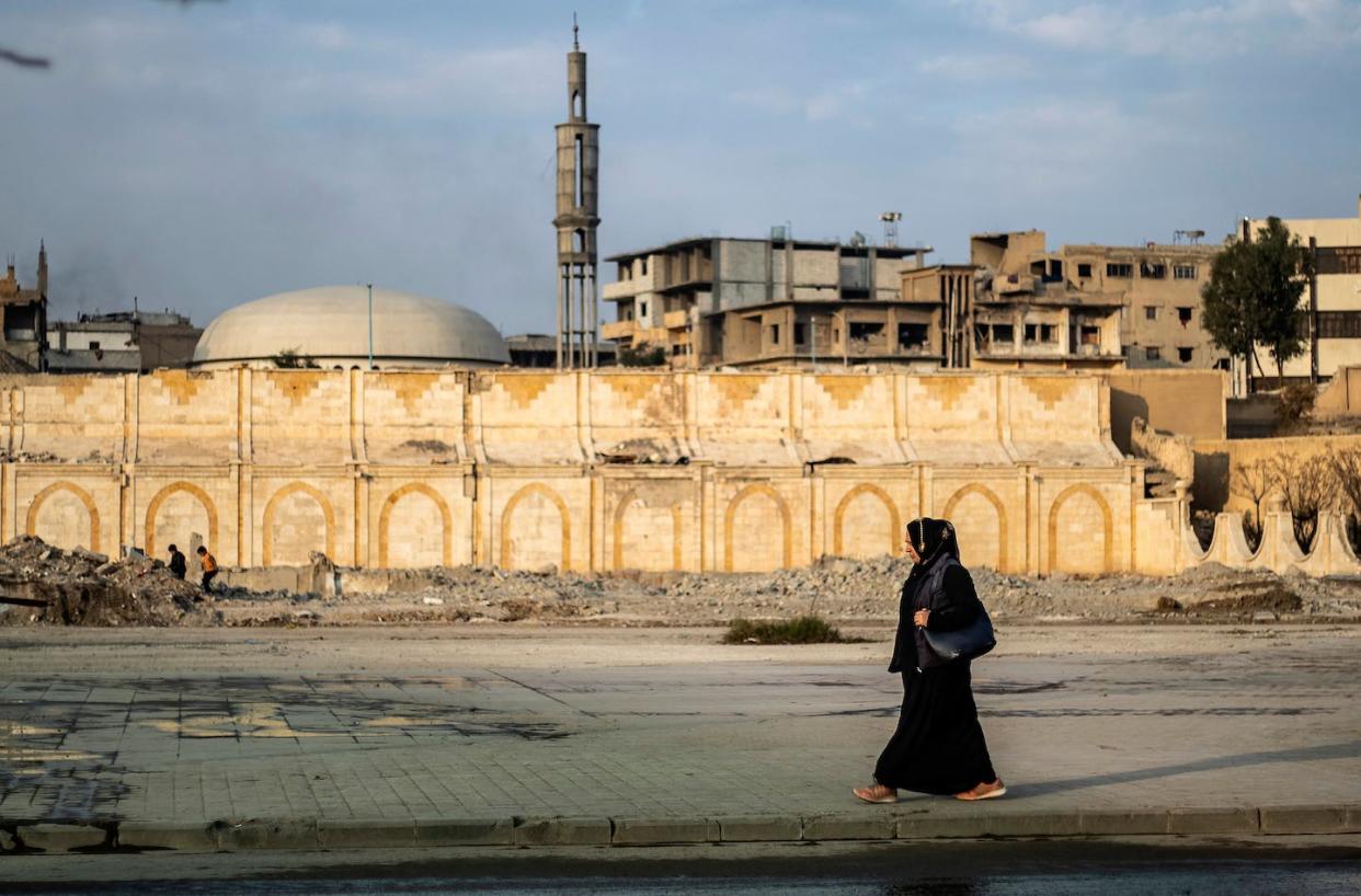 A woman walks in Raqa, the former Syrian capital of the Islamic State, in December 2020. <a href="https://media.gettyimages.com/id/1230242180/photo/topshot-syria-conflict-daily-life-raqa.jpg?s=1024x1024&w=gi&k=20&c=i-FdQOqRBmciGD8TCY0hyKF8kvbZ5ixLz7y_77mY_7E=" rel="nofollow noopener" target="_blank" data-ylk="slk:Delil Souleiman/AFP via Getty Images;elm:context_link;itc:0;sec:content-canvas" class="link ">Delil Souleiman/AFP via Getty Images</a>