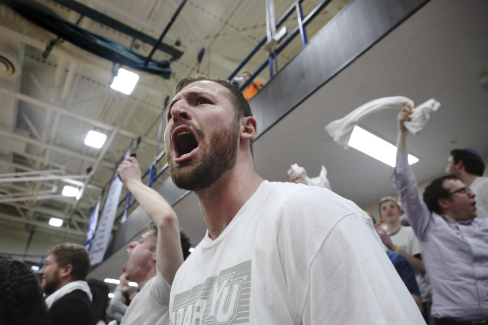 Yeshiva University student Joseph Cohn, 21, cheers in the stands during the second half of the Skyline Conference men's basketball game between Yeshiva University and Farmingdale State College in New York, Feb. 27, 2020. (AP Photo/Jessie Wardarski)