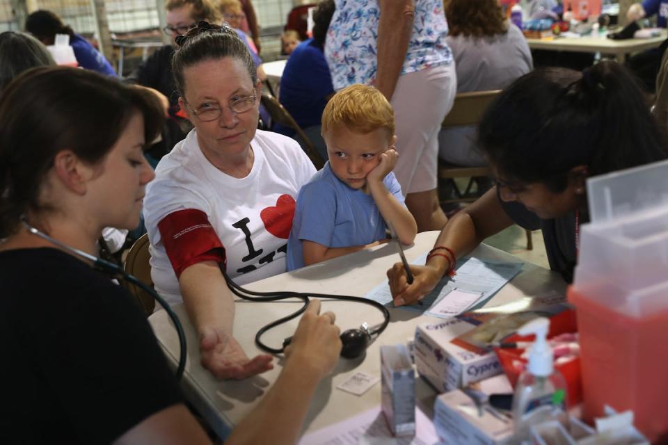 Residents waited in long lines for a free annual health clinic in Wise, Va., in 2017. A nonprofit operated the annual pop-up clinic for two decades until the state expanded Medicaid eligibility in 2019, which helped more residents afford local health care. <a href="https://www.gettyimages.com/detail/news-photo/ruby-partin-and-her-adoptive-son-timothy-huff-visit-a-free-news-photo/820902146" rel="nofollow noopener" target="_blank" data-ylk="slk:John Moore/Getty Images;elm:context_link;itc:0" class="link ">John Moore/Getty Images</a>