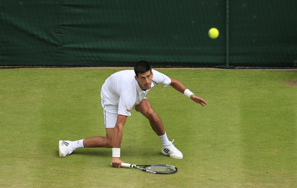 Novak Djokovic of Serbia returns to Roger Federer of Switzerland during the men's singles final at the All England Lawn Tennis Championships in Wimbledon, London, Sunday July 12, 2015. (Jonathan Brady/Pool Photo via AP)