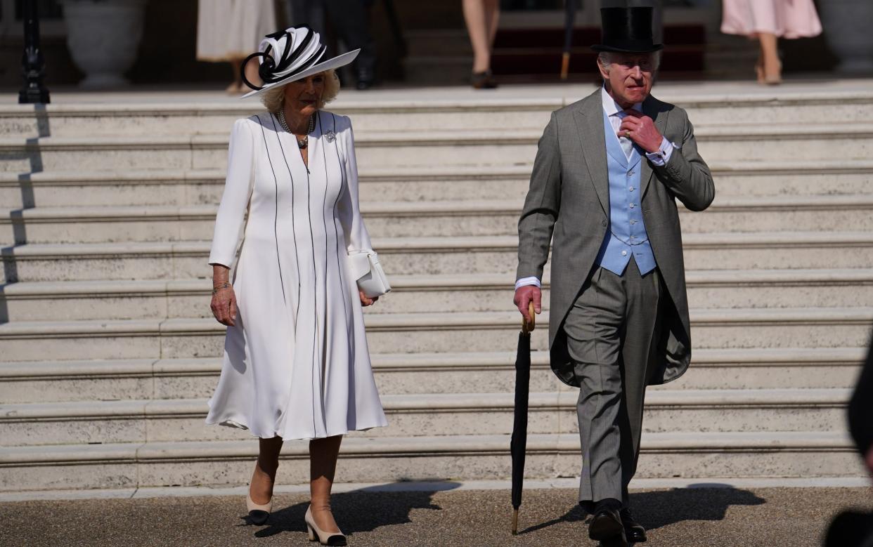 The King adjusts his tie as he and the Queen prepare to entertain guests