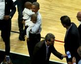 U.S. President Barack Obama holds a pair of toddlers as he greets fans at halftime of an NBA opening night game between the Cleveland Cavaliers and the Chicago Bulls in Chicago October 27, 2015. Earlier Tuesday Obama delivered remarks at an International Association of Chiefs of Police (IACP) conference and attended Democratic Party events in Chicago. REUTERS/Jonathan Ernst