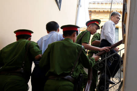 Former Petro Vietnam (PVN) chairman Nguyen Xuan Son (R) is escorted by police to the court for the verdict session in Hanoi, Vietnam September 29, 2017. REUTERS/Kham