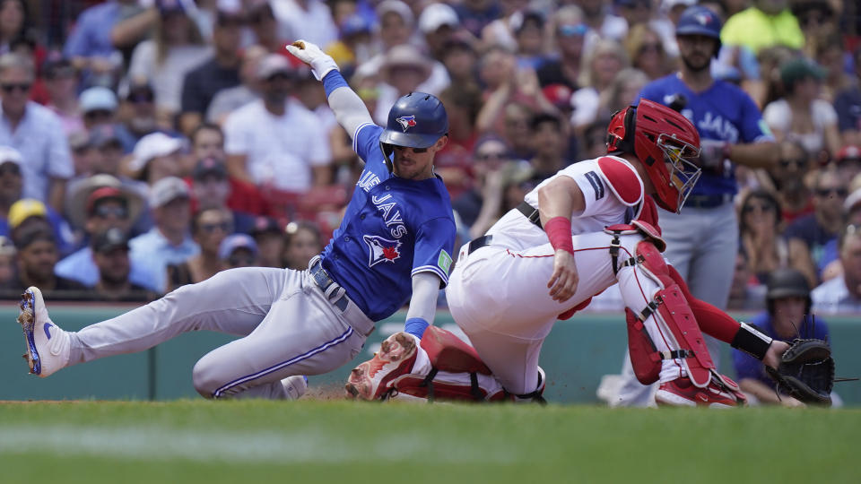 Toronto Blue Jays' Cavan Biggio, left, scores on a single by Kevin Kiermaier as Boston Red Sox's Reese McGuire, right, waits for the ball in the third inning of a baseball game, Sunday, Aug. 6, 2023, in Boston. (AP Photo/Steven Senne)