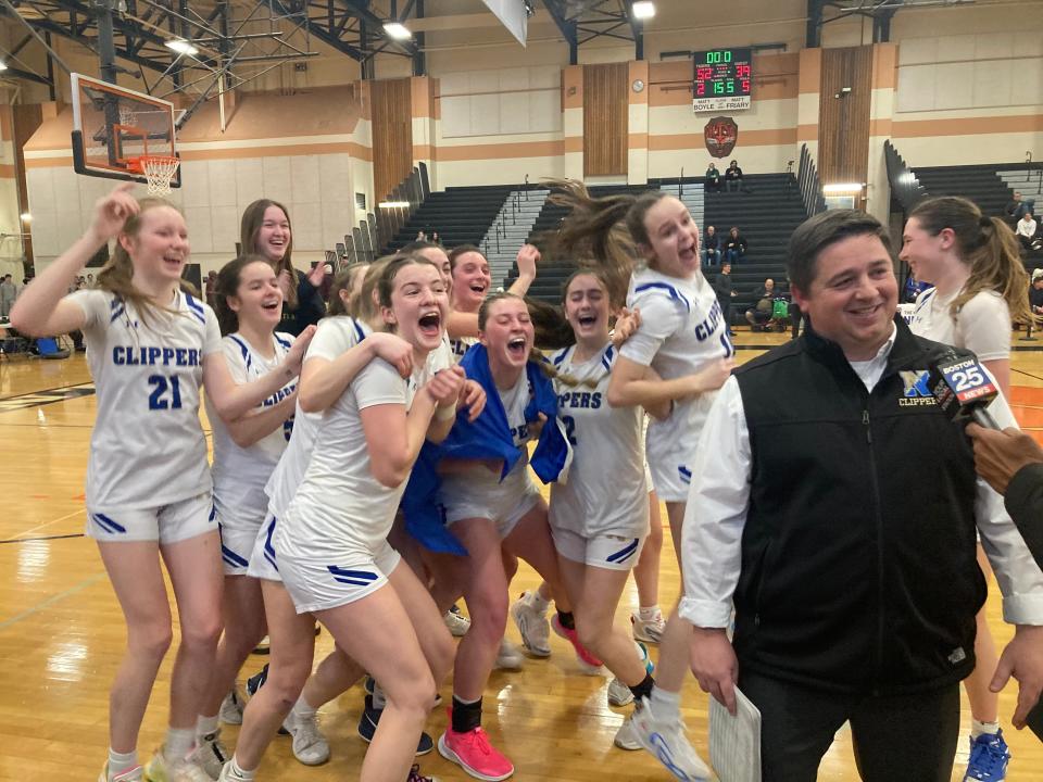 The Norwell High girls basketball team photobombs coach Matt Marani while he conducts an on-court TV interview following the Clippers' 52-39 win over Medway in the Div. 3 state semifinals at Taunton High on Monday, March 11, 2024.