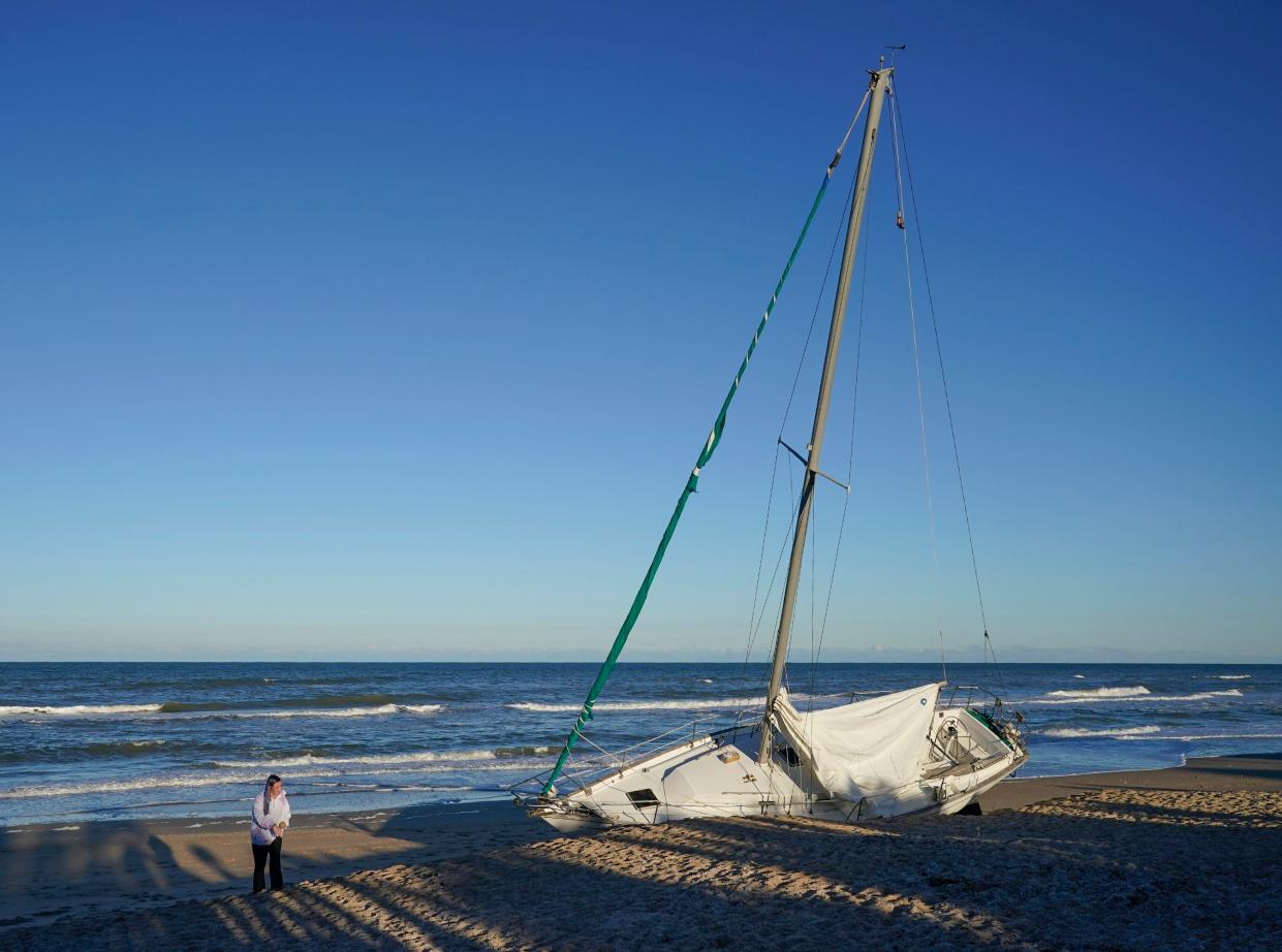 An abandoned sailboat rests on the shore in New Smyrna Beach at the Drum Avenue beach walkover, Monday, Jan. 29, 2024.