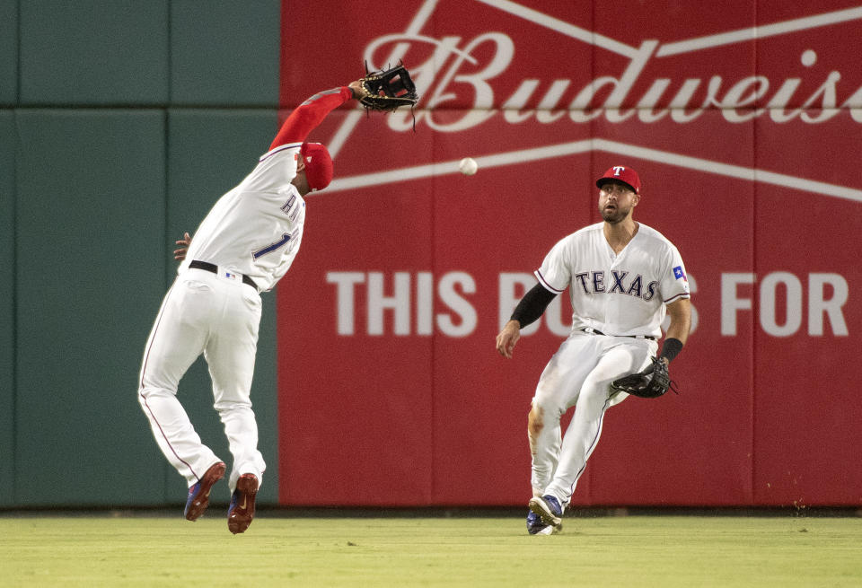 Texas Rangers shortstop Elvis Andrus (1) can't make the catch on a pop fly by Los Angeles Angels' Andrelton Simmons as left fielder Joey Gallo backs up the play during the ninth inning of a baseball game, Thursday, Aug. 16, 2018, in Arlington, Texas. Texas won 8-6. (AP Photo/Jeffrey McWhorter)