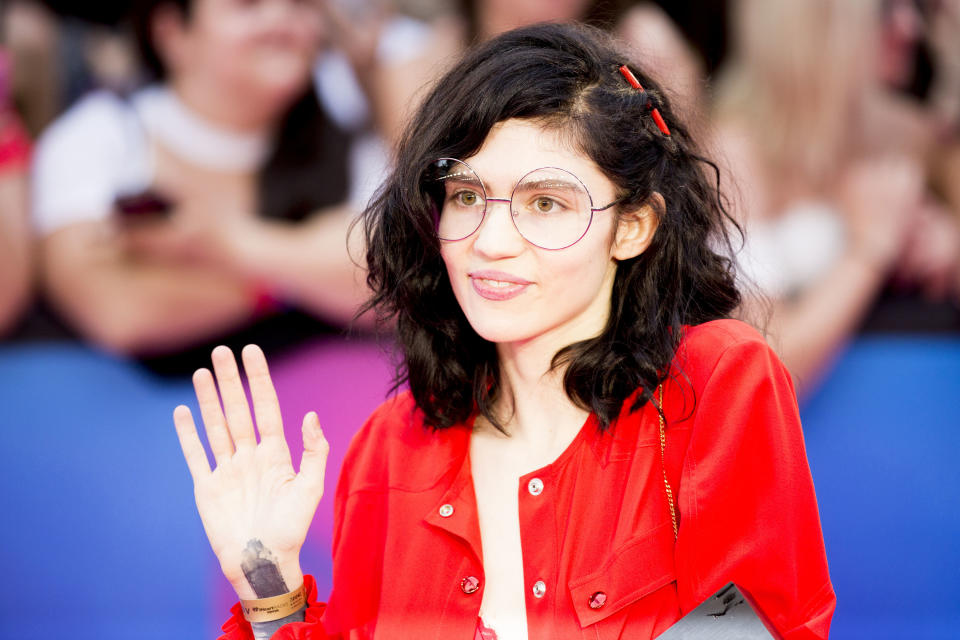 closeup of grimes waving at fans