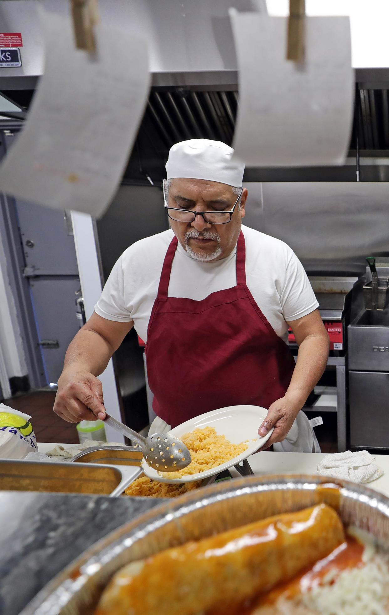 Jose Rodriguez, head chef at El Papa's, plates an order on April 23. The restaurant recently reopened on State Road in Cuyahoga Falls.