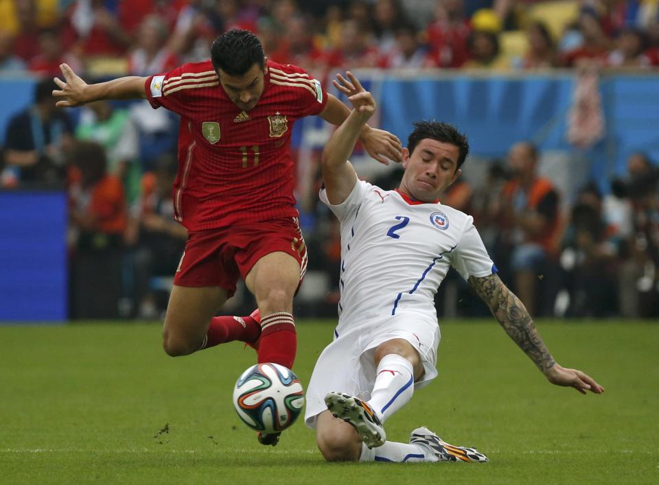 Spain's Pedro Rodriguez (L) and Chile's Eugenio Mena fight for the ball during their 2014 World Cup Group B soccer match at the Maracana stadium in Rio de Janeiro June 18, 2014. REUTERS/Jorge Silva (BRAZIL - Tags: SOCCER SPORT WORLD CUP)