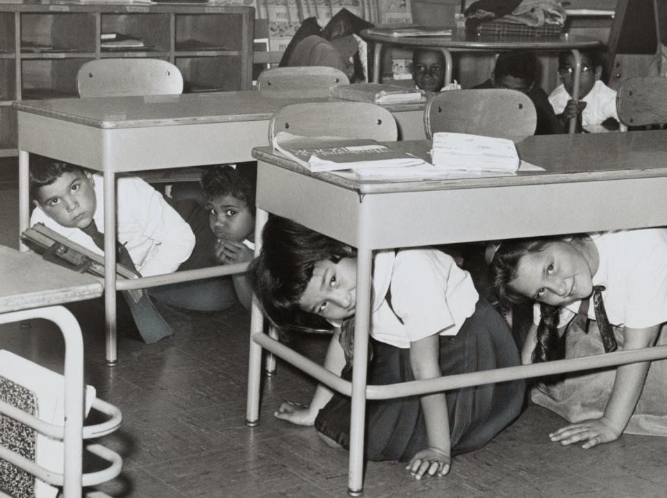 Estudiantes de una escuela de Brooklyn, Nueva York, realizan un simulacro de ataque nuclear en 1962. <a href="https://media.gettyimages.com/photos/students-at-a-brooklyn-middle-school-have-a-duck-and-cover-practice-picture-id566420175?s=2048x2048" rel="nofollow noopener" target="_blank" data-ylk="slk:GraphicaArtis/Getty Images;elm:context_link;itc:0;sec:content-canvas" class="link ">GraphicaArtis/Getty Images</a>